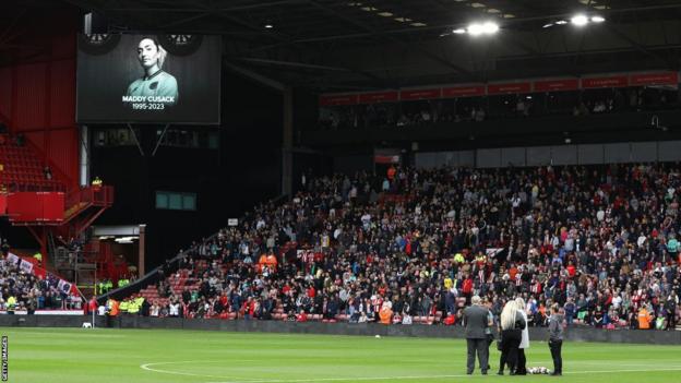 Members of Maddy Cusack's family on the pitch as an image of Cusack is displayed on the big screen at Bramall Lane