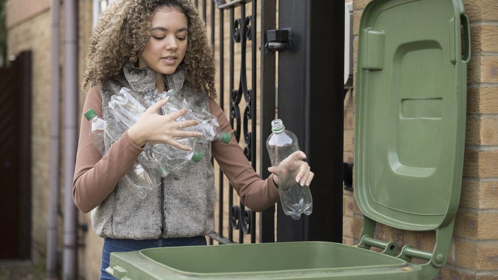 Woman putting recycling into a bin